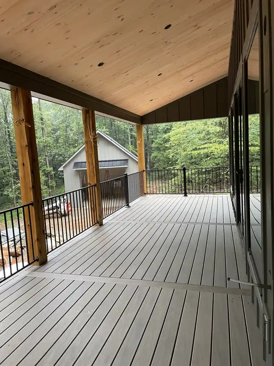 Covered deck with grey composite boards, timber posts, and black metal railing