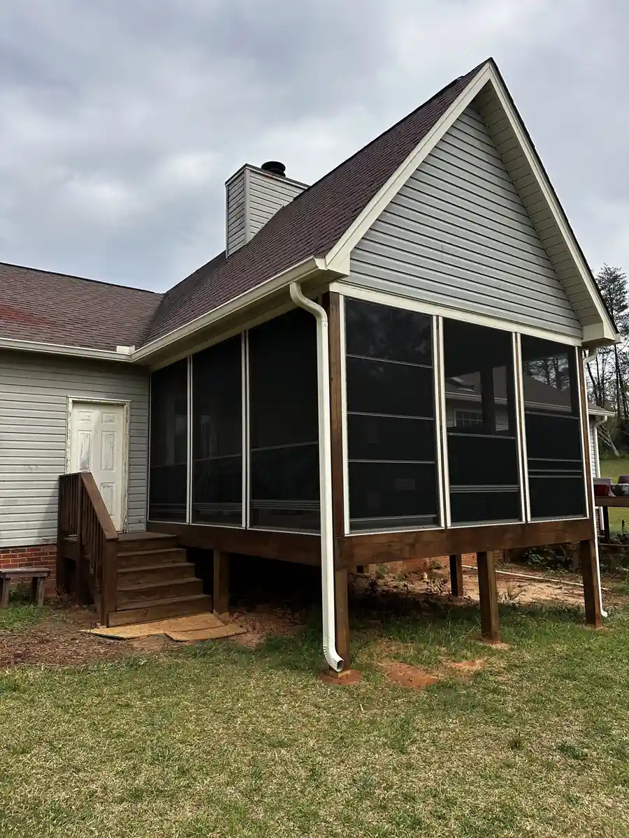 Elevated gabled porch fitted with Eze-Breeze panels on a raised wood deck with wood stairs