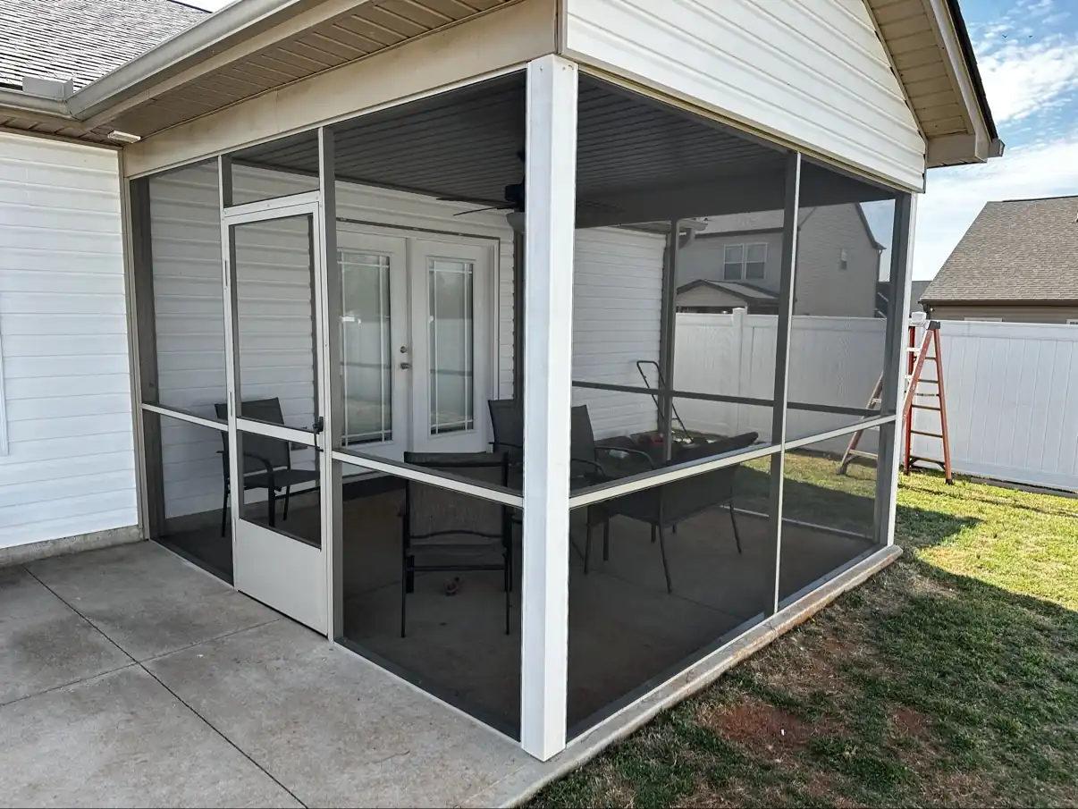 Ground-level patio screen porch with a screen door and patio chairs inside